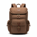 Brown canvas backpack with top flap, front pockets, and leather accents